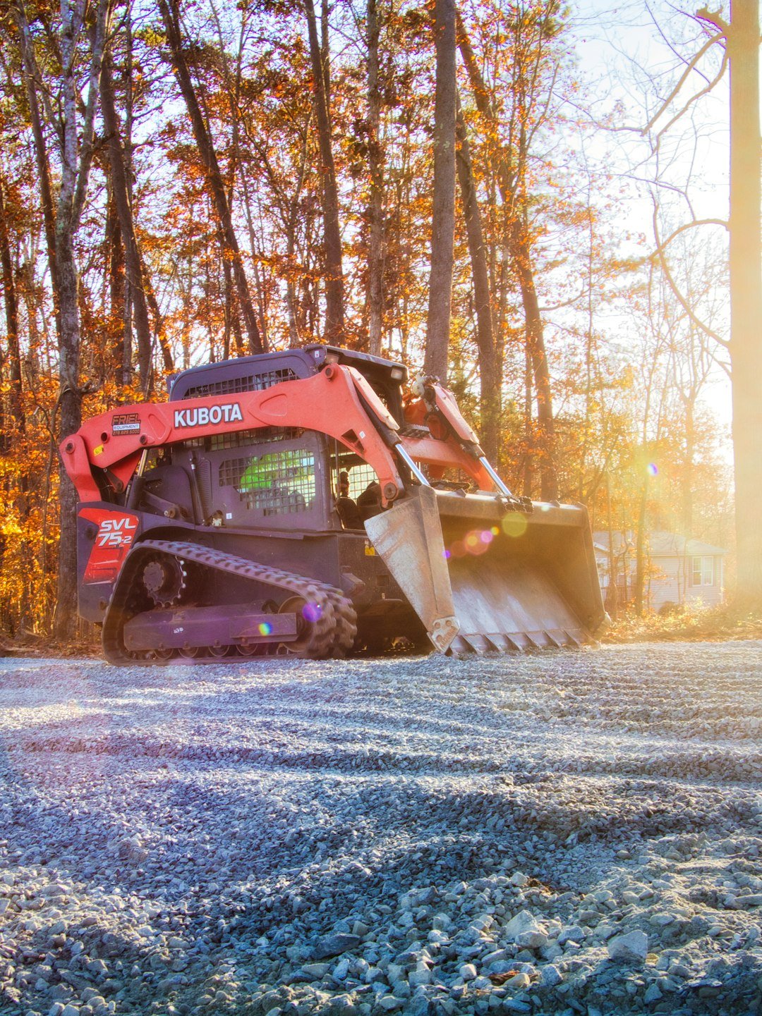 how-it-works orange-kubota-skid-steer-loader-on-gravel-road-az3krinv0ew